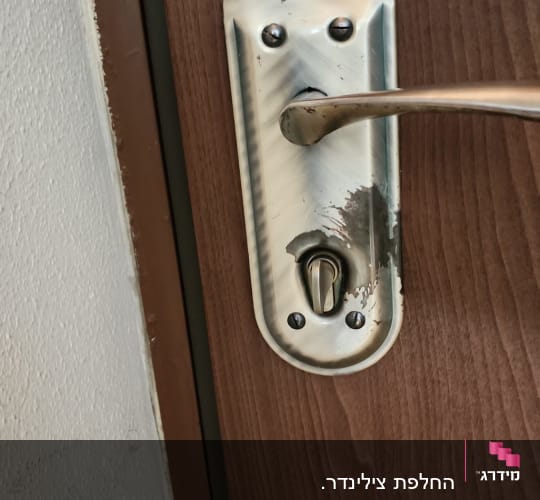 ידית דלת מתכת על דלת עץ
